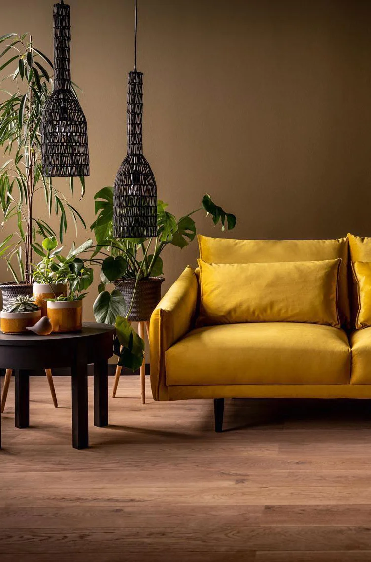 żółta sofa na tle brązowej ściany